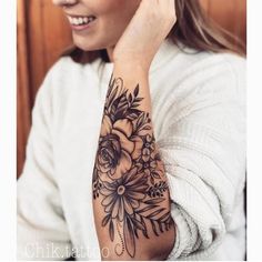 a woman with a flower tattoo on her arm