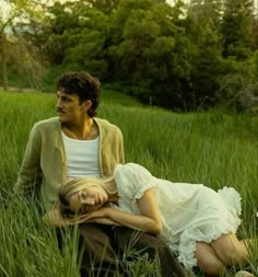 a man and woman sitting in tall grass