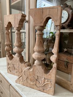 an old wooden clock sitting on top of a counter next to a cabinet and mirror