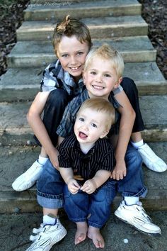 two young boys sitting on steps with their arms around each other