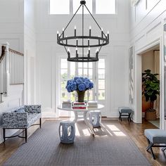 an elegant dining room with chandelier and blue hydrangeas in the center