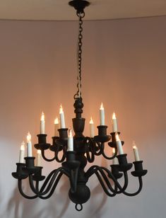 a chandelier with many lit candles hanging from it