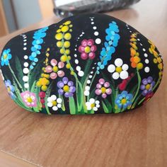 a painted rock sitting on top of a wooden table