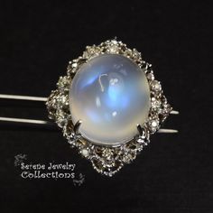 This large rare Moonstone Cabochon Ring is set in 14k solid gold and exhibits mesmerizing blue flash aduralescence. Scintillating diamonds surround this natural beauty! Ring Size: 5.75 Total Weight: 13.65 grams Precious Metal: 14k solid gold Precious stones: -Moonstone Center Stone: 18.5mm x 16.2mm, 23.05 carats -White Round Diamond: 0.4ct Elegant Multi-stone Moonstone Ring, Round Cabochon Gemstones For Wedding, Elegant Collectible Moonstone Ring, Cabochon Gemstones For Wedding, Diamond Multi-stone Moonstone Ring, Fine Jewelry White Gold Moonstone Cabochon Ring, Moonstone Diamond Ring With Multi-stone Design, Wedding Moonstone Cabochon Diamond Ring, Formal Moonstone Ring With Gemstone Accents