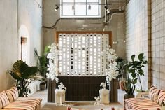 a room filled with lots of white flowers and greenery next to a fire place