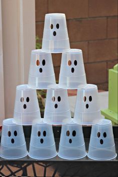 plastic cups with faces are stacked on top of each other