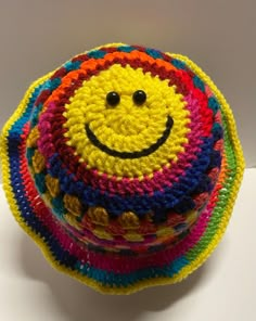 a multicolored crocheted hat with a smiley face on it