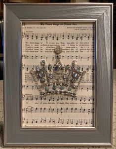 an old sheet music with a tiara on it is framed in a silver frame