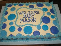 a cake with blue and white frosting that says welcome baby mason on the side