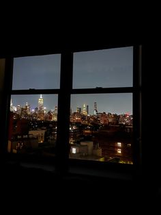 the view from an apartment window at night, with city lights in the back ground