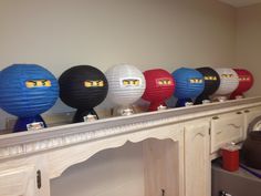 some paper lanterns are lined up on a mantle