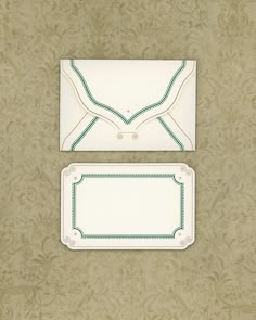 two white envelopes sitting on top of a wall