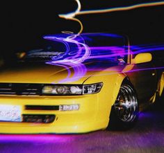 a yellow car with purple lights on it