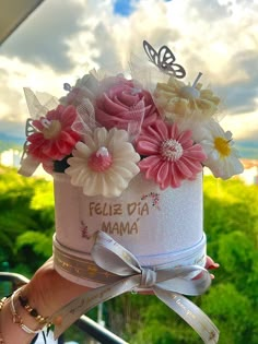 a person holding a cake with flowers on it