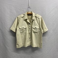 Small / 1970s Eddie Bauer Outdoorsman Button Up Khaki Shirt Pit to Pit: 21in Top Collar to Bottom: 26in Please take the time to review our shop policies listed on our homepage before purchasing. We do NOT accept returns, but will gladly accept exchanges. All items are vintage, and sold AS IS. Thank you for shopping with us! - RatRunners Vintage Khaki Shirt For Summer, Retro Khaki Button-up Shirt, Collared Khaki Top With Snap Buttons, Khaki Collared Top With Snap Buttons, Khaki Collared Shirt With Snap Buttons, Retro Collared Camp Shirt With Button Closure, Vintage Button-up Camp Shirt With Pockets, Vintage Camp Shirt With Buttons, Vintage Button-up Camp Shirt For Spring