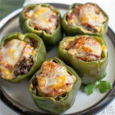 several stuffed peppers on a plate with cheese