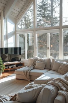 a living room filled with furniture and large windows