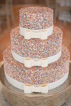 three tiered cake with sprinkles and bows