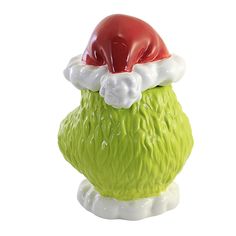 a green vase with a red santa hat on it's head, sitting in front of a white background