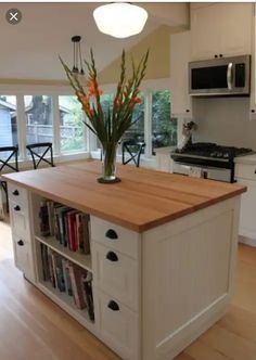 a kitchen island with bookshelves and flowers in it