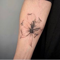 a black and white flower tattoo on the arm