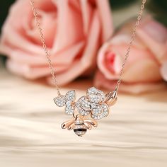 The center of the pendant showcases two delicate flowers made of sparkling stones. Symbolizing the blossoming love between two hearts. Beneath these captivating flowers, a graceful bee dangles, representing the sweet harmony of your connection. Just as the bee diligently gathers nectar for its hive, your love is a labor of love, continuously nurturing the sweetness of shared moments and experiences.Carat Weight: 1.507 ctStone Size: 1,1.2,2,0.8 mmStone Type: Jeulia® StoneNumber of Stones: 212 Sto Exquisite Flower Shaped Jewelry With Diamond Accents, Exquisite Flower-shaped Jewelry With Diamond Accents, Delicate Diamond White Flower Jewelry, Elegant Heart Pendant Jewelry With Flower Charm, Rose Gold Flower-shaped Necklace With Diamond Accents, Diamond Pendant With Flower Charm, Rose Gold Flower Shaped Necklace With Diamond Accents, Rose Gold Necklace With Diamond Accents And Flower Pendant, Rose Gold Diamond Flower Jewelry