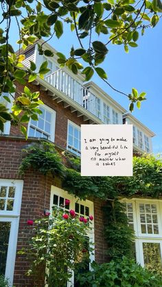 a brick house with vines and flowers growing on the front door, next to a sign that says i am going to make a very special visit