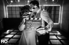 a man and woman standing next to each other in front of a movie clapper