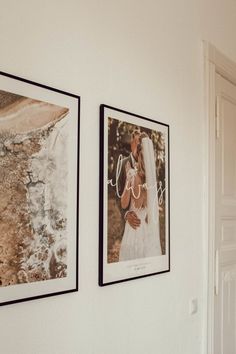 two framed photos hang on the wall next to each other in a room with white walls