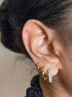 a close up of a person with ear piercings on their ears and behind the ear