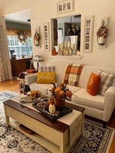 a living room filled with furniture and pictures hanging on the wall above it's coffee table