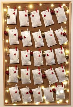 a bulletin board with notes pinned to it and christmas lights on the wall behind it