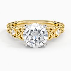 a yellow gold engagement ring with a round cut diamond in the center