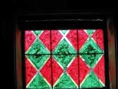 a red and green glass window in a dark room