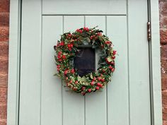 a green door with a wreath hanging on it