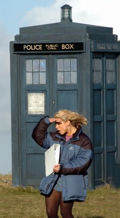 a woman standing in front of a police box