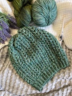 two skeins of yarn next to each other on top of a blanket with lavender flowers