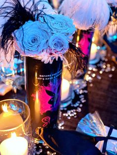 a table with candles and flowers in vases next to other decorations on the table