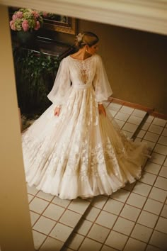 a woman in a wedding dress is standing on the floor next to a piano and flowers