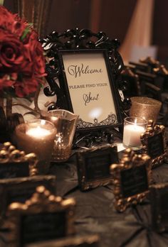 a table topped with candles and framed pictures