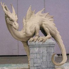 a statue of a dragon sitting on top of a stone block wall in front of a purple door