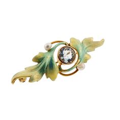 "A fine Art Nouveau 14K yellow gold enameled pin with swirling foliage surrounding a bezel-set aquamarine. The enamel is worked in delicate translucent enamel in shades of blue, green and cream. Small seed pearls flank the nicely-colored aquamarine. The clasp is marked with Krementz' 14K hallmark. NOTE: We are also offering a matching pin set with an amethyst and enameled in shades of violet (Item #1414819) * Origin: America, ca 1900 * Condition: excellent; two 1/16\" enamel nicks barely visible Elegant Blue Enamel Pin, Elegant Green Enamel Pin, Shades Of Violet, Shades Of Blue Green, Lapis Ring, Gold Brooch, Bird Brooch, Gold Brooches, Victorian Art