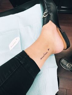 a woman's foot with a small tattoo on her left ankle and the word love written in cursive writing