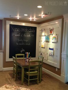 there is a chalkboard in the corner of this room with chairs and a table