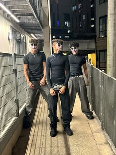 three young men with their faces painted like they are standing on a platform in the city