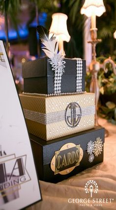 three boxes are stacked on top of each other at a table with candles and decorations