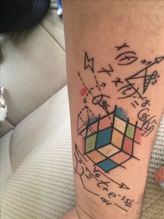 a person with a tattoo on their leg that has an image of a rubix cube