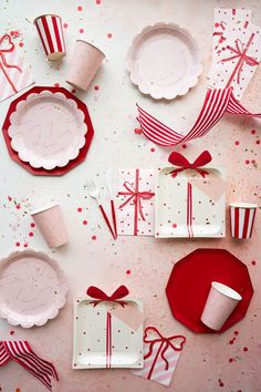 red and white table setting with paper plates, napkins, cups, and bows