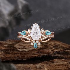 a white diamond and blue topazte ring on a piece of wood with rocks in the background