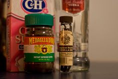 some spices are sitting on a table next to a bottle